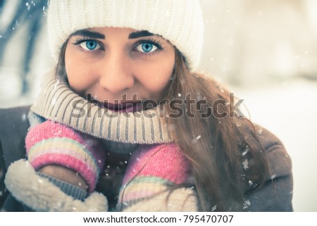 Beautiful woman at cold and snowy winter walking at New York city. Warmly dressed in a coat with a hat.