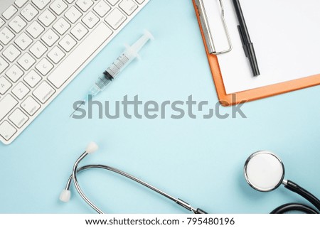 Top view of a medical doctor desk. Pastel blue background.