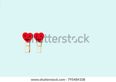 two red mini heart wood clip  on light blue background