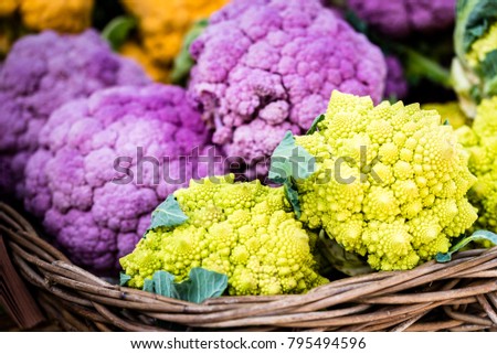 Colorful organic fresh vegetables in wooden boxes displayed at market, closeup, selective focus. 
Vivid green romanesco broccoli, purple and orange cauliflower at market stall, Sydney, Australia.
 Royalty-Free Stock Photo #795494596