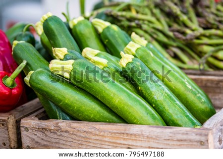 Organic fresh vegetables in wooden boxes displayed at market, closeup, selective focus.
Zucchini, asparagus, red capsicum at market stall, Sydney, Australia.

 Royalty-Free Stock Photo #795497188