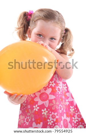 Young girl in a pink flowery dress with a yellow balloon