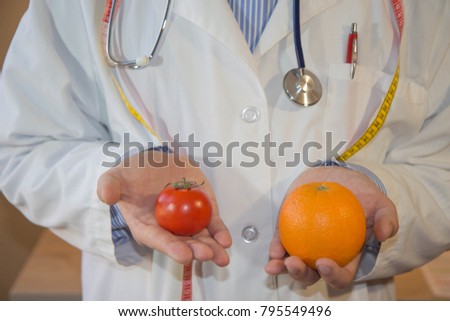 The idea of healthy diet, dietary breakfast. Losing weight with the help of a fruit diet. Doctor or nutritionist hold an tomato and orange