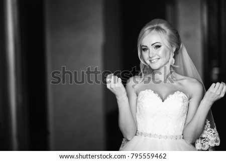 Beautiful bride in weddind dress posing to photographer. Black and white