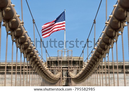 American flag on Brooklyn Bridge, with blue sky, New York CIty