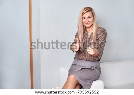 Attractive female showing thumbs up in an office