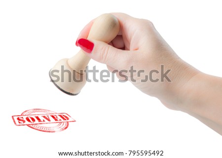 Hand holding a rubber stamp with the  word solved isolated on a white background