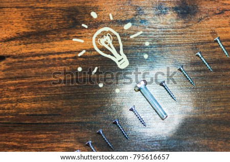 A group of screws on a wooden background, and the bolt is not like the others. A painted light bulb, there are people who are not like everyone else, and their potential is unknown