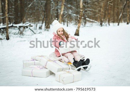 little girl in a sleigh with gifts