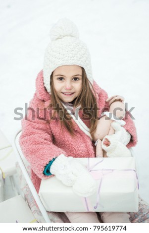 little girl in a sleigh with gifts