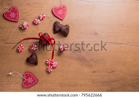 Valentine's day concept. Hearts and candyâ??s decoration on the wooden surface. Top down view with copy space.