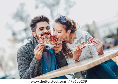 Couple eating pizza snack outdoors.They are sharing pizza and eating. Royalty-Free Stock Photo #795635239