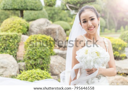 Beautiful Asian bride wearing wedding dress smile and holding bouquet,Feeling so proud and happiness in wedding day