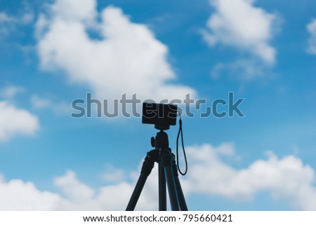 Compact digital camera stand on tripod photographing, Blue sky and cloud landscape.
