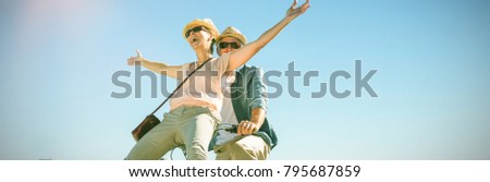 Happy casual couple going for a bike ride on the pier on a sunny day