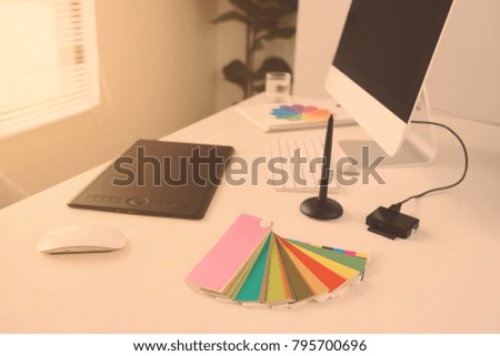 Modern office workplace with desktop computer, stylus and tablet for retouching