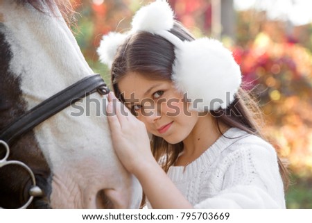 Pretty young girl with a white horse.