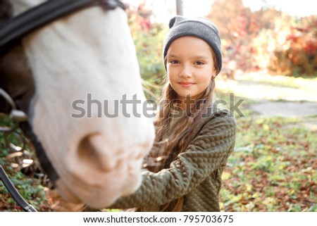 Portrait of beautiful girl with a chestnut pony