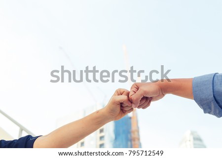 business man and woman fist bumping for celebration and successful concept on constuction background Royalty-Free Stock Photo #795712549