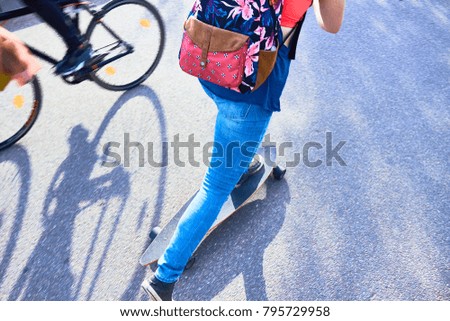 girl on a skateboard, rolling on the road. Feet of girl riding longboard