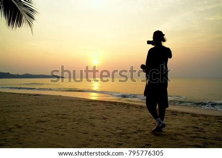 Men standing at the beach, back in black silhouette