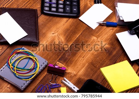 Office supplies and business idea concept. Wallet and office tools on wooden background. Stationery and calculator. Business cards, binders, elastics, clips, notebook and clothespins near stickers