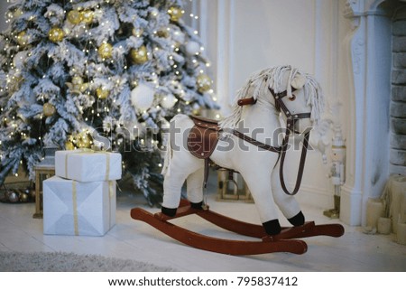 A toy white horse on the background of a Christmas tree