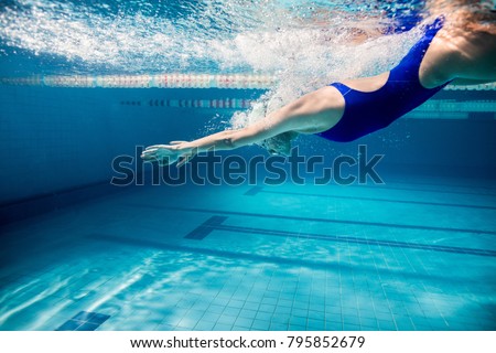 underwater picture of young female swimmer exercising in swimming pool