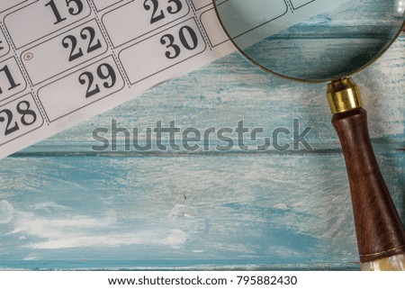 Calendar and Magnifying Glass On  Wooden Table