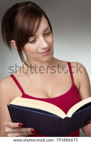 shot in the studio of young fitness woman reading a book