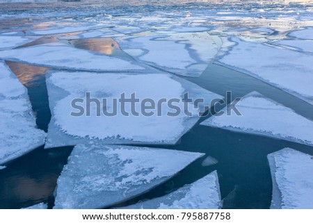 Ice sheets forming various shapes on frozen lake