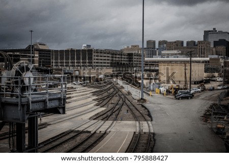Tracks leading to buildings in urban area with cloudy skies