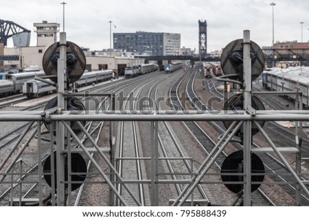 Looking down tracks through light stand with cloudy skies