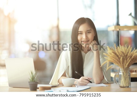 Asian business woman working in in coffee shop cafe with laptop paper work  (Business woman concept.)