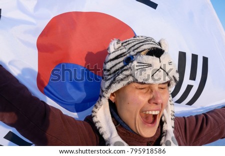 A girl in a hat with a white tiger on the background of a South Korean flag.