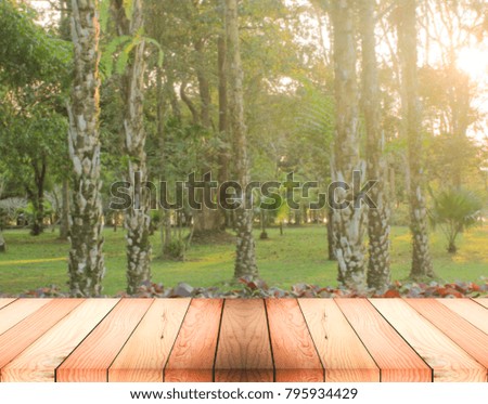 Empty wooden deck table with autumn forest background. Ready for product display montage