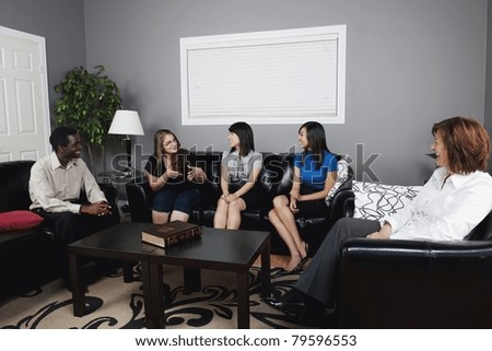 A Group Of People Talking In A Living Room Royalty-Free Stock Photo #79596553