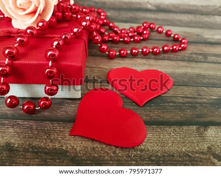 red heart, gift box beads wooden background