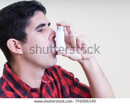 Hispanic man using an inhaler Royalty-Free Stock Photo #796006540