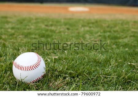Baseball on field with base and outfield in background. Royalty-Free Stock Photo #79600972