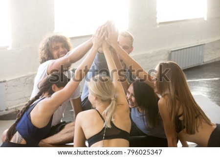 Group of young sporty people celebrating giving friends a high five. Assemble the team building, encouraging members to work well together, raised hands, gesture of greeting, good-fellowship triumph Royalty-Free Stock Photo #796025347