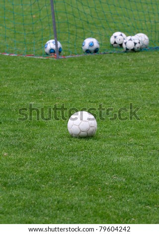 soccer balls on grass in stadium