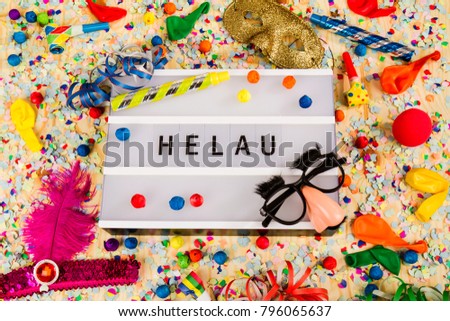 Lightbox with letters - HELAU - (Happy Carnival in German) on colorful festive party decoration with steamers, confetti and ballons.