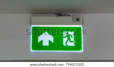 Green emergency exit sign. Direction to the escape way on white background