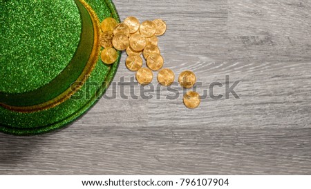 Treasure of pure gold eagle coins inside the rim of a green velvet hat to celebrate luck on St Patrick's Day of March 17th