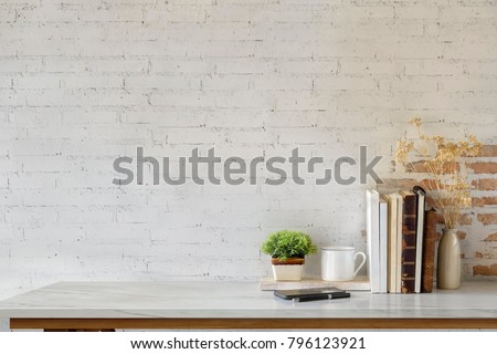Marble desk with books, coffee mug, mobile phone and plant. Mock up