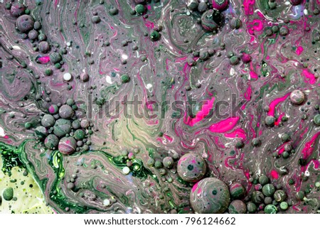 Toxic chemical acrylic oil droplets on water creating the idea of pollution concepts ideas and themes in bright vibrant colours, as the circle globules release on the liquid surface. Abstract globes