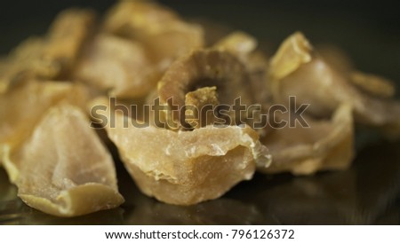 Banana chips and crumbs against plain black background. Dried fruits on black background