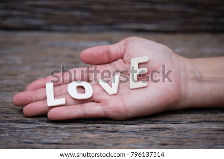 Wooden letters word "LOVE" on woman's hand, Valentine day concept background.