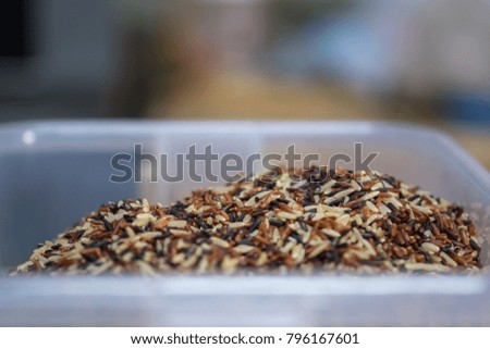 mixed uncooked rice in transparent plastic container